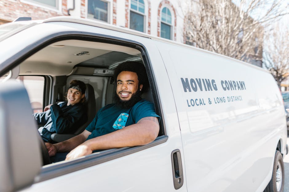 Professional movers smiling while carrying boxes